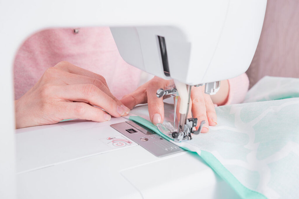Hände beim Nähen an der Nähmaschine