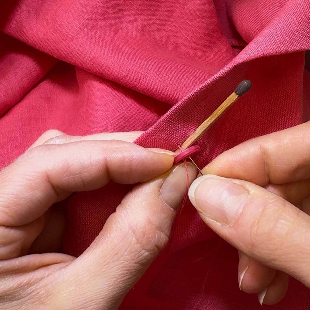 Streichholz als Abstandshalter beim Knopfannähen